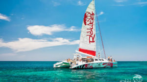 Red and white boat on the water with group travelers on board