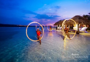 Performers dancing with rings of fire in the ocean