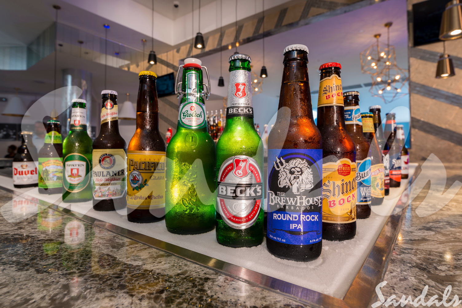 Beer bottles placed in a triangular format over a bed of ice